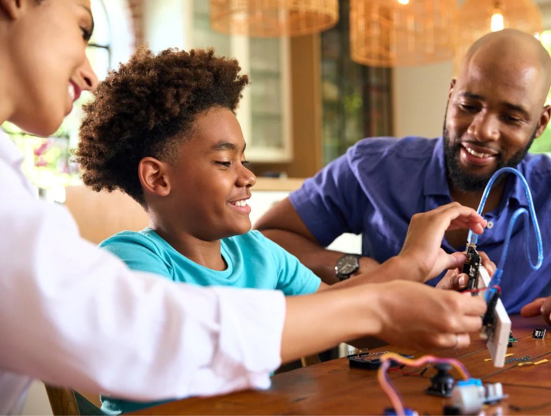 A child and two adults engage in simple STEM activities