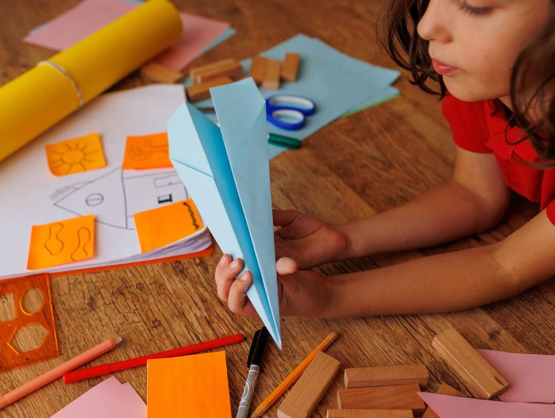 Young girl in red shirt engaging in easy STEM activities with paper
