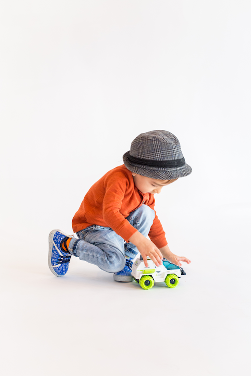 Little Boy Playing with Toy while wearing Kazoom High Top Spaceship Shoes in Blue