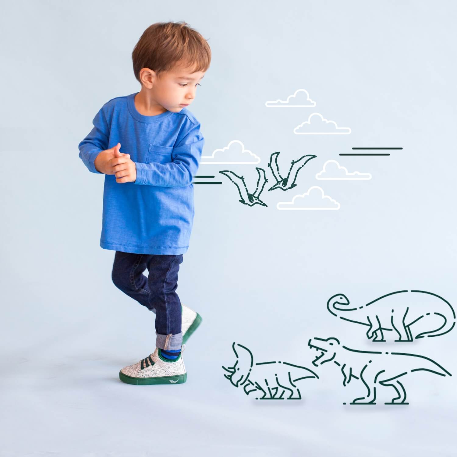 Dinosaur high tops - Toddler boy wearing green and white Digging Dinos toddler shoes with boy being chased by t-rex, triceratops &amp; Brachiosaurus