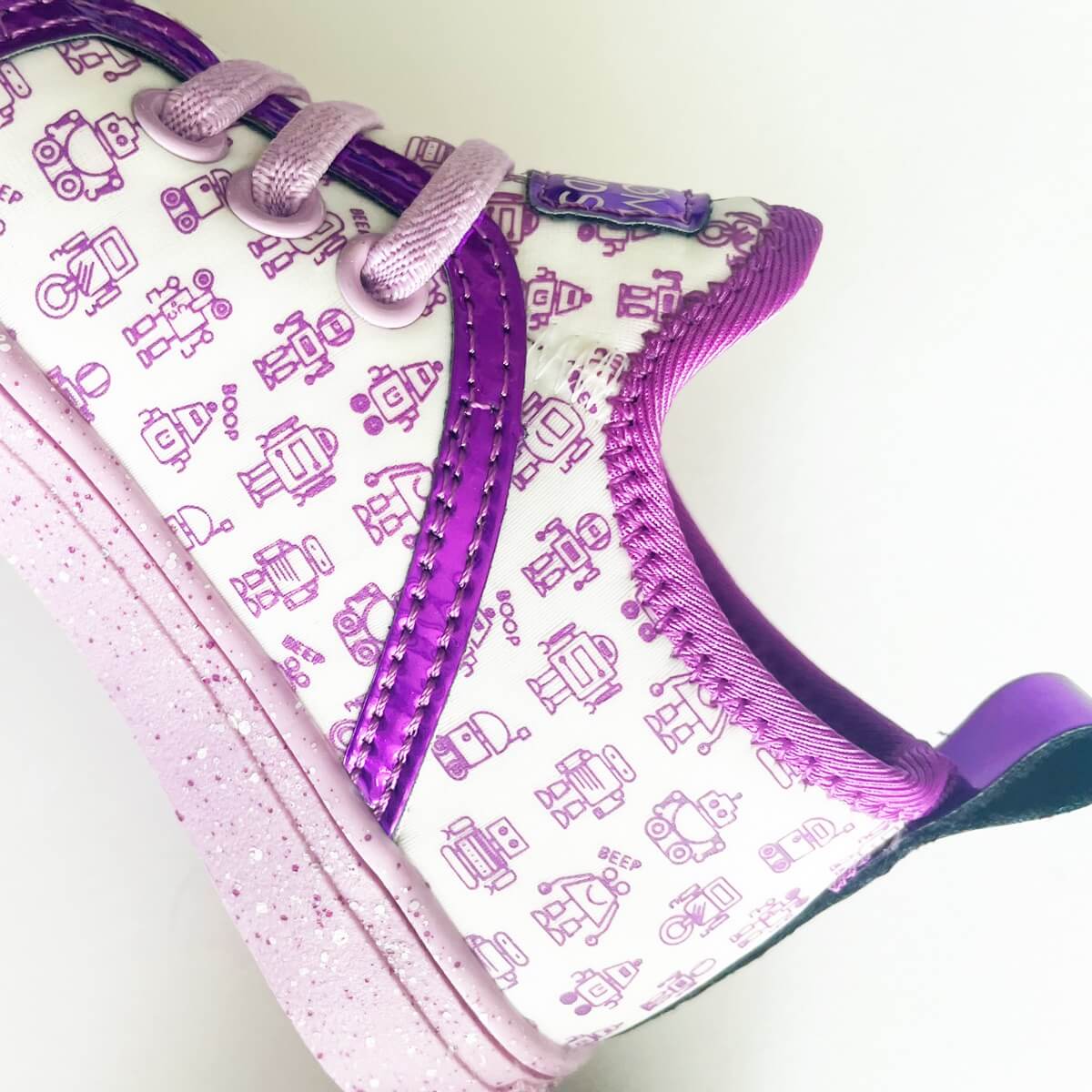 Zoomed in image of Girls Purple and white Robot Kid Shoes in a Toddler Size showing speckled soul and iridescent stripes, available in Toddler, kids, and youth sizes